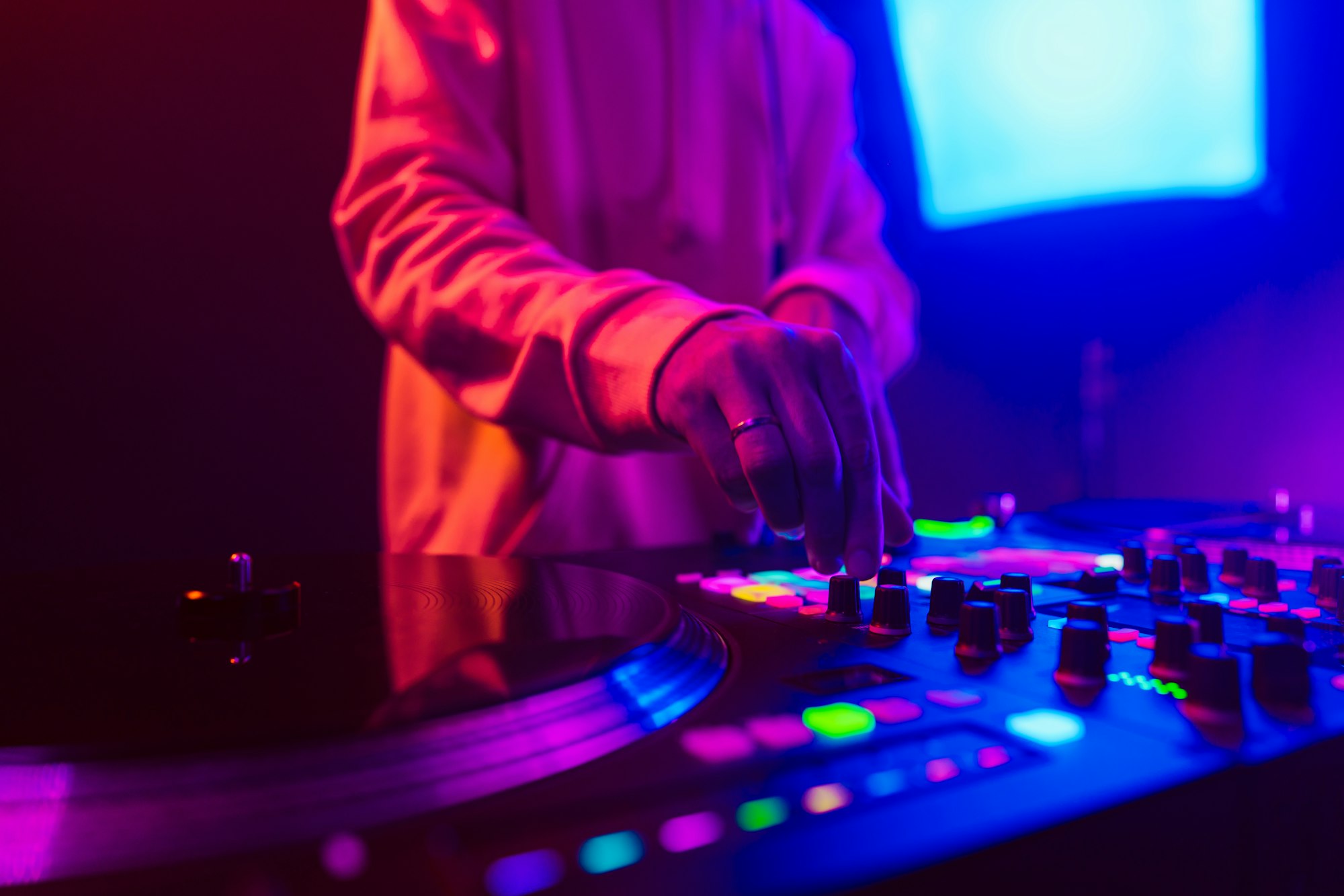 Hands of a DJ creating and regulating music on dj console mixer at club concert