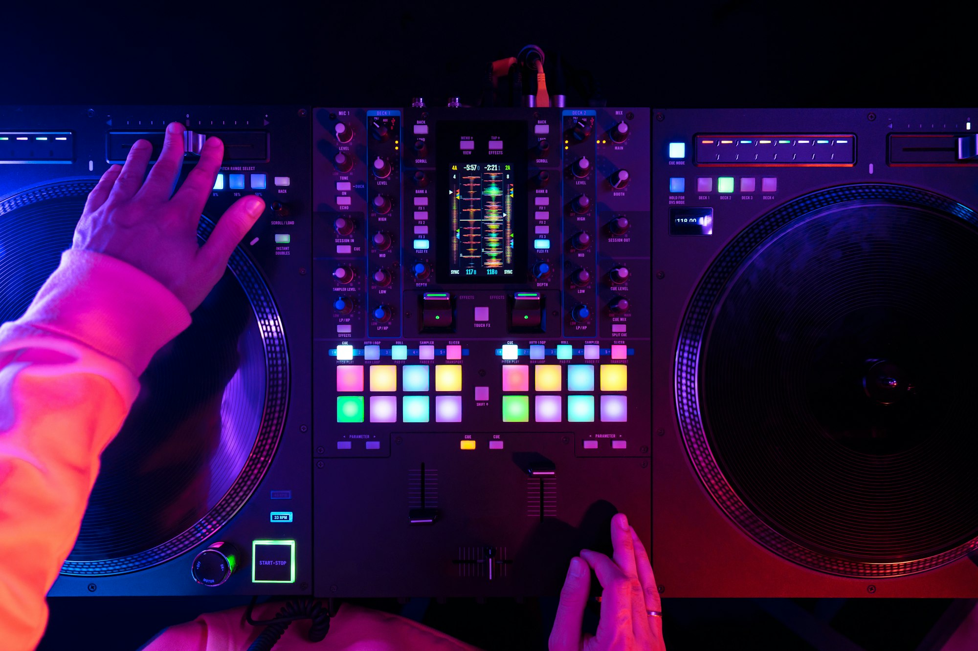 Hands of a DJ creating and regulating music on dj console mixer at club concert